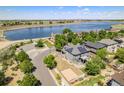 Aerial view of home with solar panels, a fenced yard, and a lake view in a tranquil neighborhood at 9530 E 113Th Ave, Commerce City, CO 80640
