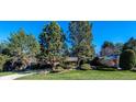 Beautifully landscaped front yard with mature trees adding shade and curb appeal to this brick home at 4000 S Clermont St, Cherry Hills Village, CO 80113