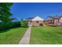 Quaint single-story home featuring a vibrant green lawn and cozy, inviting curb appeal at 755 S Clay St, Denver, CO 80219