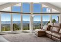 Living room filled with natural light with beautiful mountain views and a brown leather couch at 12672 Rancho Ct, Conifer, CO 80433