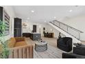 Bright living room with modern decor, open floor plan, and a staircase with metal railings at 2530 Lawrence St # Ra101, Denver, CO 80205