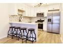 A view of a kitchen featuring stainless steel appliances, white cabinets and a peninsula at 6960 E Girard Ave # 404, Denver, CO 80224