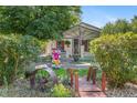 Charming front yard with a decorative bridge, lush greenery, and inviting curb appeal at 6480 W 60Th Ave, Arvada, CO 80003