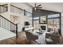 Open living room with a fireplace, high ceilings, a cozy layout, and a connection to the second-floor landing at 16564 High Desert Way, Parker, CO 80134