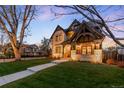 Stunning exterior evening shot of a two-story home featuring stone accents and manicured landscaping at 2495 S Madison St, Denver, CO 80210
