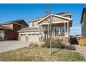 Charming two-story home with a three-car garage, covered porch, and solar panels for energy efficiency at 6021 Lynx Creek Cir, Erie, CO 80516