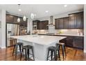 Stylish kitchen features a large island, dark wood cabinets, and stainless steel appliances at 3890 Tabor Ct, Wheat Ridge, CO 80033