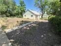 Quaint home featuring a spacious gravel driveway and yard with mature trees, offering plenty of outdoor space at 444 S Jersey St, Denver, CO 80224