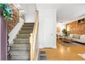 Entryway featuring a staircase and exposed brick, leading to a living room with hardwood floors at 3375 W 37Th Ave, Denver, CO 80211