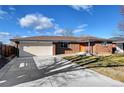 Brick ranch home with attached garage and well-manicured lawn at 323 Fulton St, Aurora, CO 80010