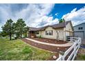 Attractive ranch home with charming front porch, manicured garden beds, and picket fence at 5685 Columbine Ridge Rd, Elizabeth, CO 80107