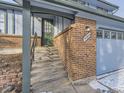 Close up of covered front porch featuring brick accents, stairs and address on house at 4589 S Evanston St, Aurora, CO 80015