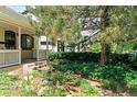 Landscaped front exterior with a covered porch, lush plantings and shade trees at 3319 Newton St, Denver, CO 80211