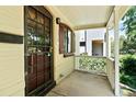 Cozy front porch with a decorative security door, classic railing, and shade from mature trees at 3319 Newton St, Denver, CO 80211
