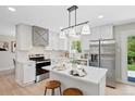 Modern kitchen featuring white cabinets, stainless steel appliances, and a center island with seating at 2646 S Pagosa Way, Aurora, CO 80013