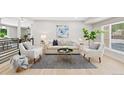 Bright living room featuring neutral furniture, light wood floors, and a stylish area rug at 2646 S Pagosa Way, Aurora, CO 80013