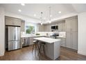 Modern kitchen with stainless steel appliances, gray cabinetry, a kitchen island, and sleek countertops at 8400 W 52Nd Ave, Arvada, CO 80002