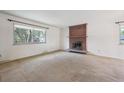 Bright living room with large window and brick fireplace at 7264 S Platte Canyon Dr, Littleton, CO 80128