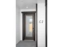 Close-up of the modern glass front door, dark trim, and contemporary hardware at 8530 W 52Nd Ave # C2, Arvada, CO 80002