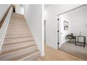 Bright entryway featuring a staircase, light wood floors, and an open doorway to an office space at 8530 W 52Nd Ave # C2, Arvada, CO 80002