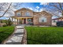 Inviting two-story home featuring a covered porch, stone accents, and a well-manicured lawn at 3422 Vestal Loop, Broomfield, CO 80023