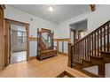 Foyer showcasing hardwood floors, wood trim, staircase, and a vintage mirror with bench at 1317 Birch St, Denver, CO 80220