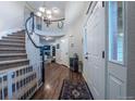 Grand entryway featuring a staircase, wood floors, a chandelier, and a view into the living spaces at 7176 S Pierson St, Littleton, CO 80127