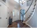 Inviting foyer showcases hardwood flooring, staircase, chandelier, and natural light from the front door at 7176 S Pierson St, Littleton, CO 80127
