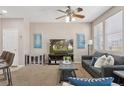 Open-concept living room with a gray sofa, large TV, neutral decor, and hardwood flooring at 17326 Waterhouse Cir # B, Parker, CO 80134