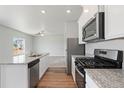 Modern kitchen featuring stainless steel appliances, granite countertops, and an open layout at 7322 Green River Ave, Frederick, CO 80530
