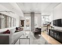 Open living room with exposed ceiling, modern decor, stairs, and balcony access at 1620 Little Raven St # 109, Denver, CO 80202