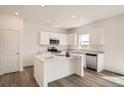 Sunlit kitchen with white cabinetry, stainless steel appliances, central island and modern lighting fixtures at 15296 Fillmore St, Thornton, CO 80602