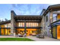 Expansive stone patio offers seamless indoor-outdoor living, complete with comfortable seating and an outdoor dining area at 132 N Gold Flake Ter, Breckenridge, CO 80424
