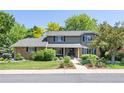 Daytime view of the two-story home showcasing its landscaped front yard, brick accents, and classic architectural style at 3726 E Nichols Ave, Centennial, CO 80122