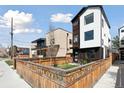 Modern home with wood and white exterior, plus a lawn and wooden fence at 1386 Zenobia St, Denver, CO 80204