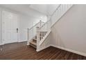 Inviting entryway with wood floors, staircase, and a white front door at 13920 Hanging Lake St, Parker, CO 80138