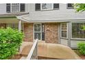 Charming townhouse front entrance with brick facade, decorative door, and well-manicured landscaping at 9930 W Progress Pl, Littleton, CO 80123