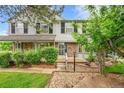 Inviting townhouse exterior with brick accents, lush greenery, and a cozy front porch at 9930 W Progress Pl, Littleton, CO 80123