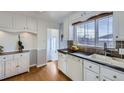 Kitchen boasts white cabinets, stainless steel appliances, and granite counters at 4840 Depew St, Denver, CO 80212