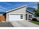 Beautiful home featuring a modern garage door, gray siding, and a well maintained lawn at 719 S Hoover Ave, Fort Lupton, CO 80621