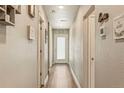 Bright hallway with hardwood floors, neutral paint, and doors leading to multiple rooms at 719 S Hoover Ave, Fort Lupton, CO 80621