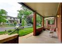 Inviting front porch with brick columns, a swing, and a view of the street at 1731 S Ogden St, Denver, CO 80210