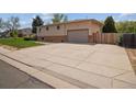 Features a large, extended concrete driveway that leads to the attached garage at 3229 Swadley St, Wheat Ridge, CO 80033