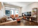 Bright living room with large windows, hardwood floors, a cozy fireplace and comfortable seating at 1333 Elati St # 3, Denver, CO 80204