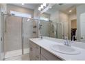 Bright bathroom boasts double sinks, a large mirror, and a glass-enclosed shower with tiled walls at 2785 Black Hawk Pl, Brighton, CO 80601