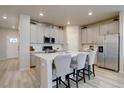 Modern kitchen features white cabinets, stainless steel appliances, and an island with bar seating at 2785 Black Hawk Pl, Brighton, CO 80601