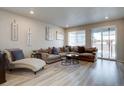 Cozy living room with a large sectional sofa, modern decor, and natural light at 2785 Black Hawk Pl, Brighton, CO 80601