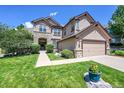 Stunning home exterior with stone accents, an arched entrance, and manicured landscaping at 3311 Klondike Pl, Castle Rock, CO 80108