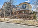 Attractive two-story home featuring a mix of brick and stucco, a small balcony, and mature landscaping at 325 S High St, Denver, CO 80209