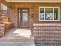 Charming brick home featuring a glass-paneled front door and a neatly maintained porch at 325 S High St, Denver, CO 80209